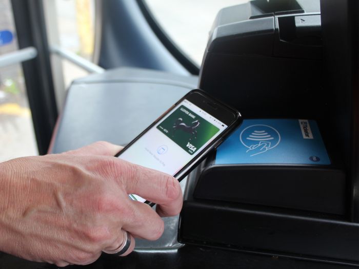 Photo of a customer using Apple Pay on a Damory or Tourist bus