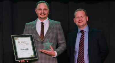 Nathan Clarke stood next to MD Ed Wills with his certificate and trophy